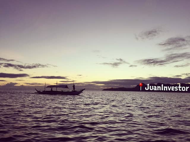 A boat sailing at sunset